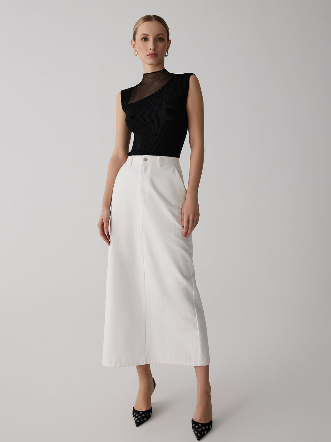 Modieuze mouwloze dames top met chique hoge ribbelkraag. Veelzijdig en ideaal voor warm weer.