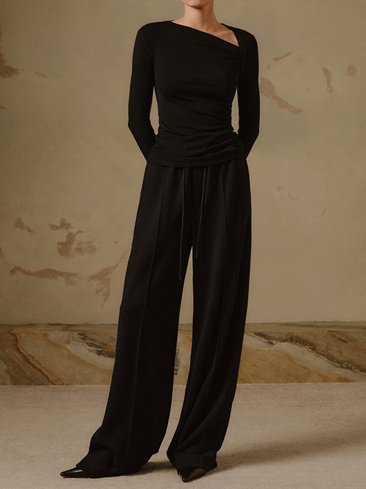 Modieuze getailleerde dames top met lange mouwen en unieke asymmetrische halslijn. Trendy basistop.