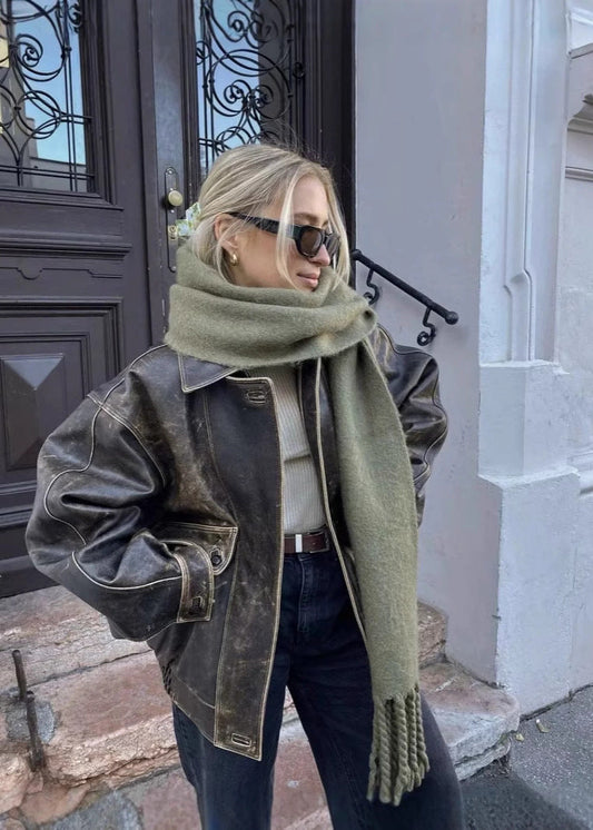 Vintage bruine leren jas met robuuste uitstraling, ideaal voor een chique, modebewuste vrouw. Elegant en tijdloos ontwerp.