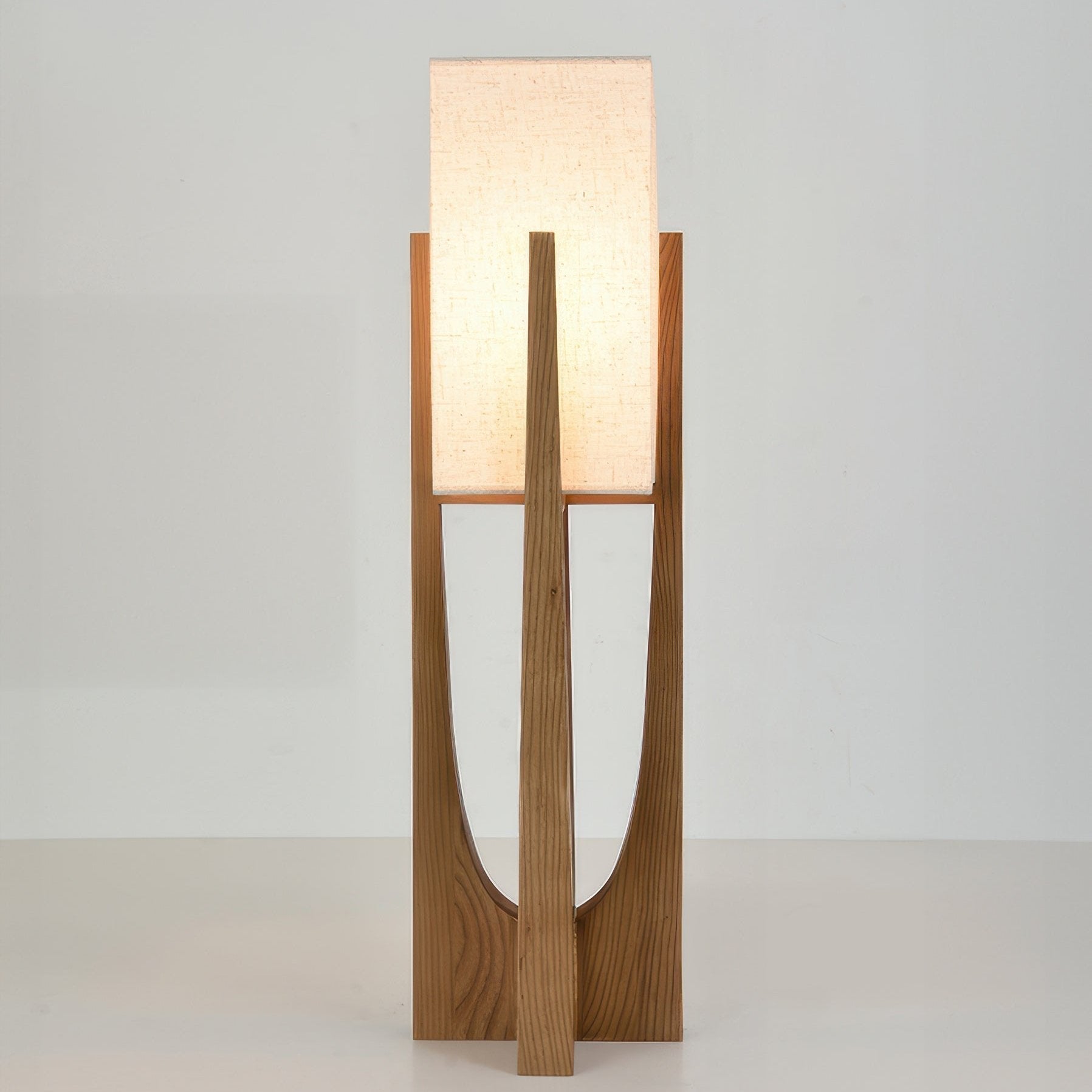 Vloerlamp met walnotenhouten basis, messing accenten en katoenen kap; minimalistisch en elegant voor sfeervol interieur.