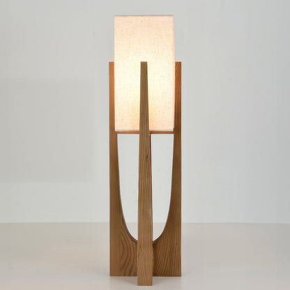 Vloerlamp met walnotenhouten basis, messing accenten en katoenen kap; minimalistisch en elegant voor sfeervol interieur.