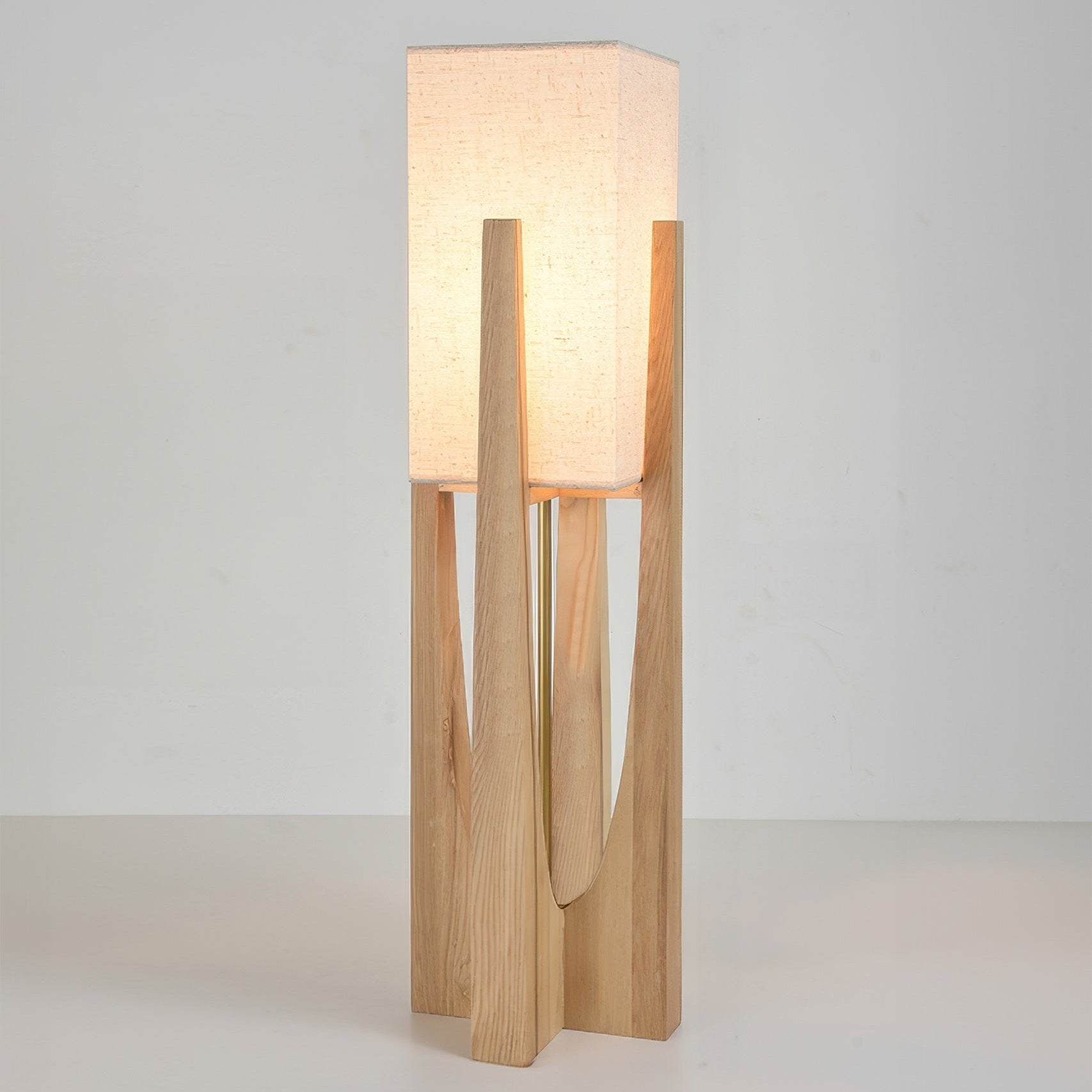 Vloerlamp met walnotenhouten basis, messing accenten en katoenen kap; minimalistisch en elegant voor sfeervol interieur.