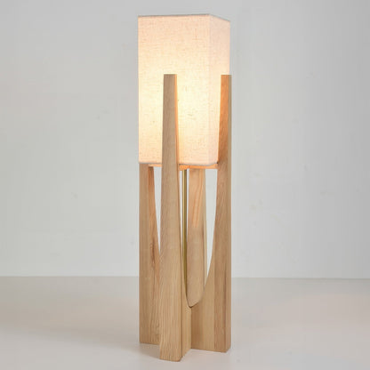 Vloerlamp met walnotenhouten basis, messing accenten en katoenen kap; minimalistisch en elegant voor sfeervol interieur.