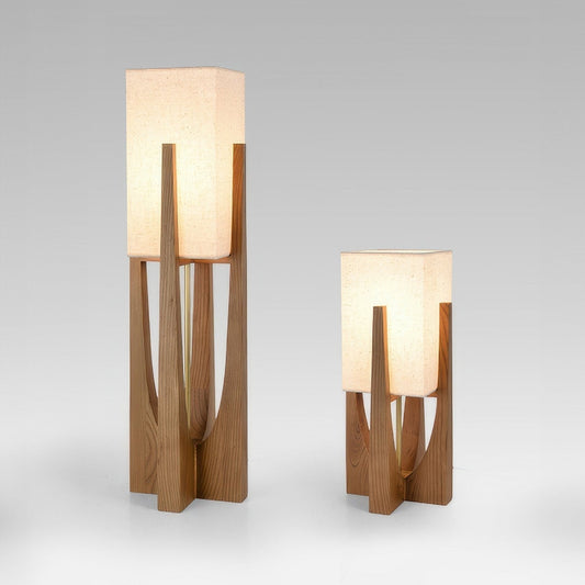 Vloerlamp met walnotenhouten basis, messing accenten en katoenen kap; minimalistisch en elegant voor sfeervol interieur.