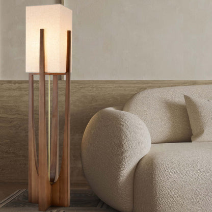 Vloerlamp met walnotenhouten basis, messing accenten en katoenen kap; minimalistisch en elegant voor sfeervol interieur.
