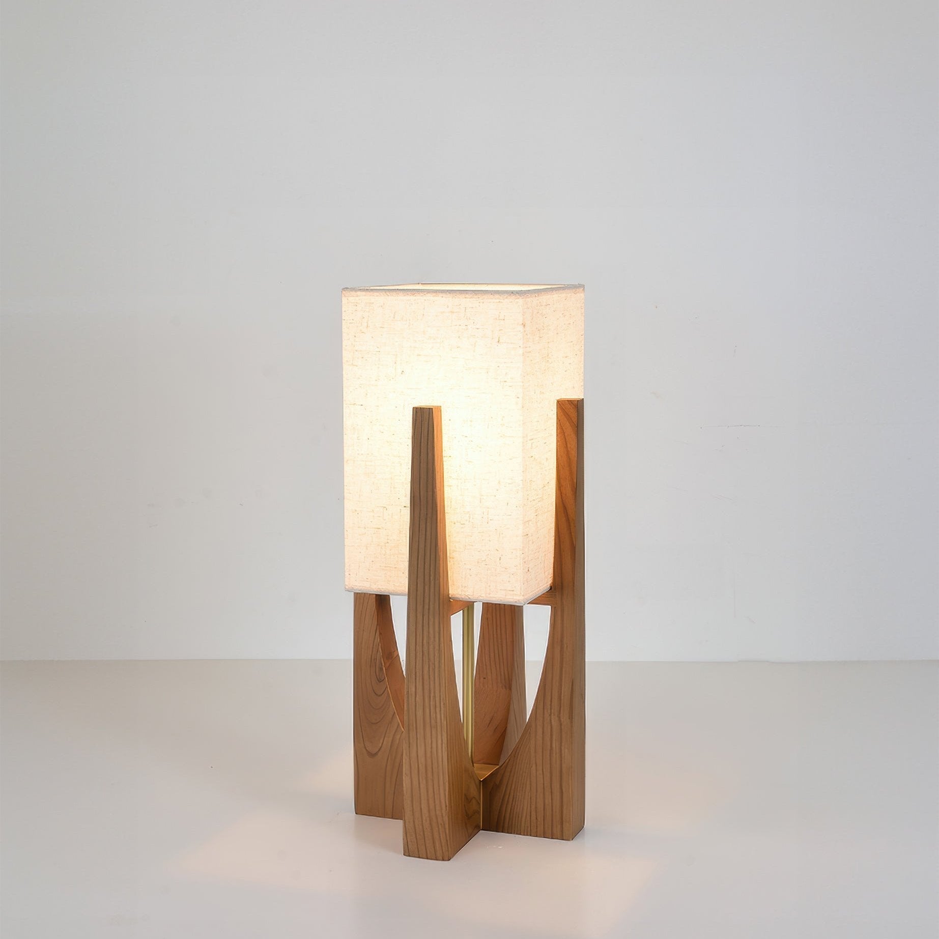 Vloerlamp met walnotenhouten basis, messing accenten en katoenen kap; minimalistisch en elegant voor sfeervol interieur.