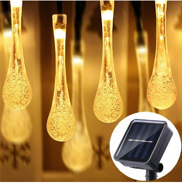 Gedetailleerde close-up van druppelvormige LED-lampjes op solar lichtketting, warm wit sfeerlicht.