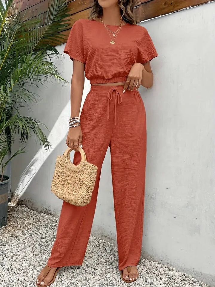 Zomerse damesoutfit: tweedelige set met unieke vleermuismouwen top en comfortabele broek. Casual chic.