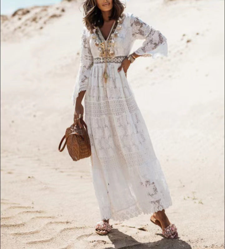 Model draagt beige dames boho maxi jurk Elvira. De lange jurk met V-hals en franjes is een perfecte bohemian strandjurk.