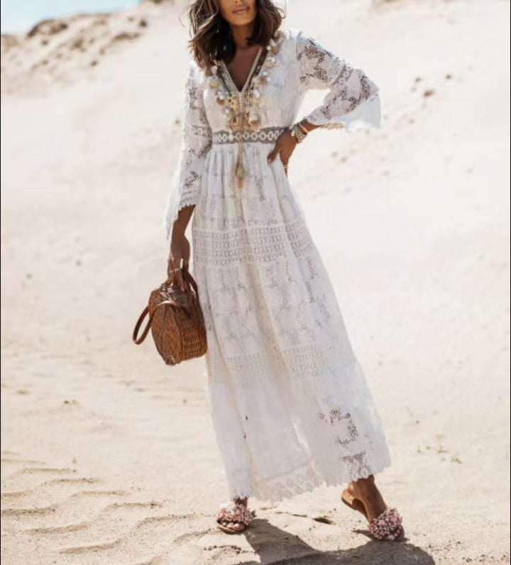 Model draagt beige dames boho maxi jurk Elvira. De lange jurk met V-hals en franjes is een perfecte bohemian strandjurk.
