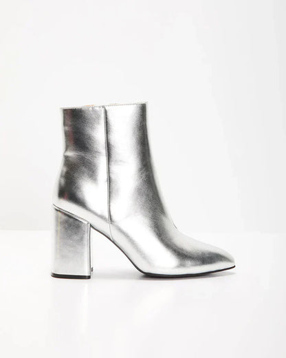 Zilveren metallic enkellaars met glamour blokhak, puntige neus en ritssluiting. Verhoog je stijl met deze elegante laarsjes.