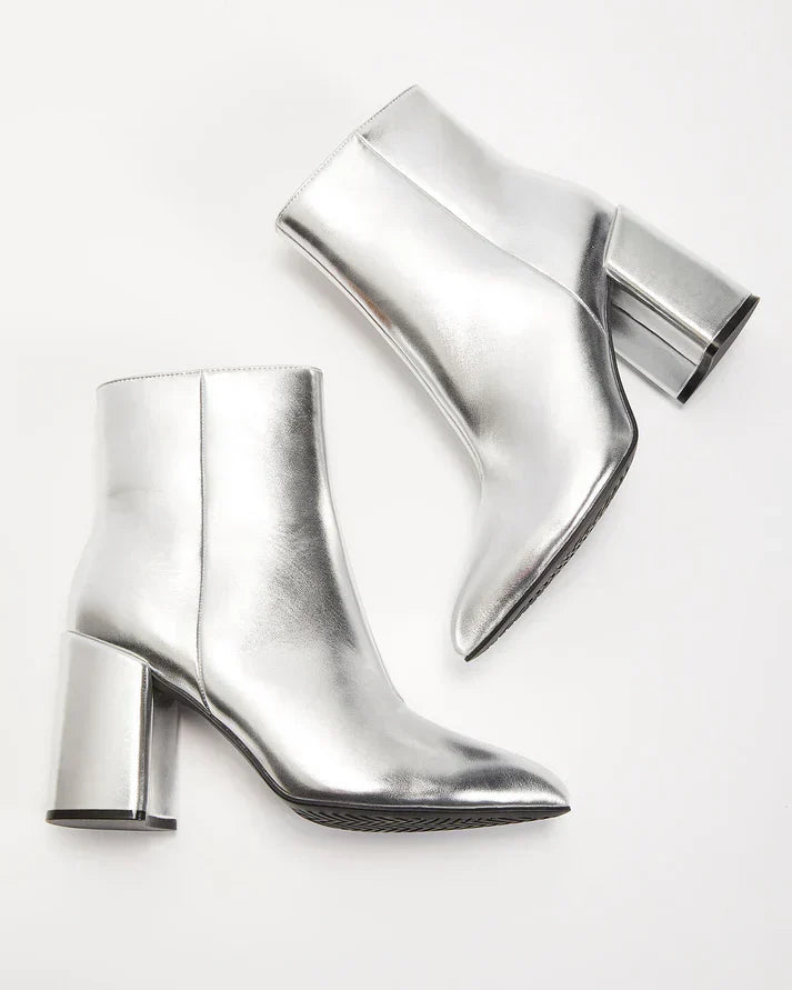 Zilveren metallic enkellaars met glamour blokhak, puntige neus en ritssluiting. Verhoog je stijl met deze elegante laarsjes.