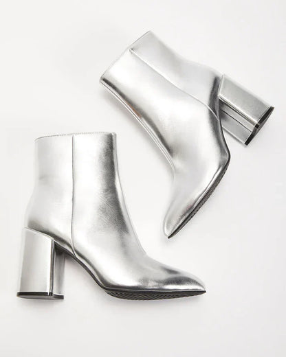 Zilveren metallic enkellaars met glamour blokhak, puntige neus en ritssluiting. Verhoog je stijl met deze elegante laarsjes.