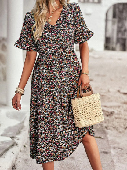 "Zomerjurk met bloemenpatroon en V-hals in abrikoos; elegante, casual damesjurk voor een stijlvolle zomerlook."