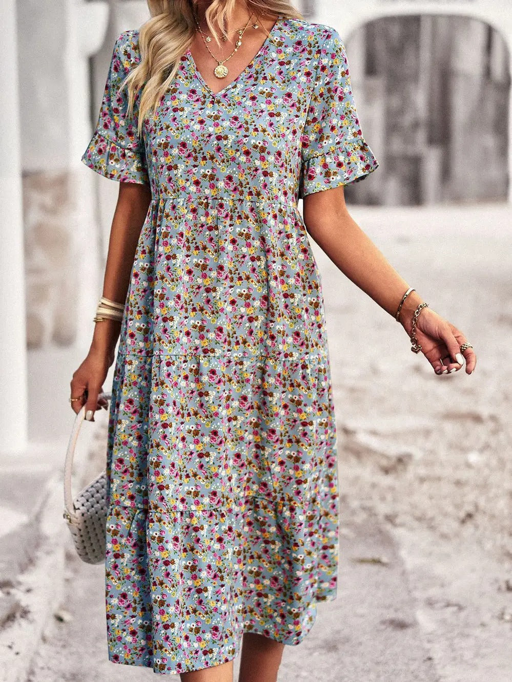 "Zomerjurk met bloemenpatroon en V-hals in abrikoos; elegante, casual damesjurk voor een stijlvolle zomerlook."