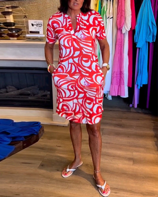 "Zomerjurk met korte mouwen, rood-witte abstracte print, casual en speels, perfecte outfit voor warme dagen."