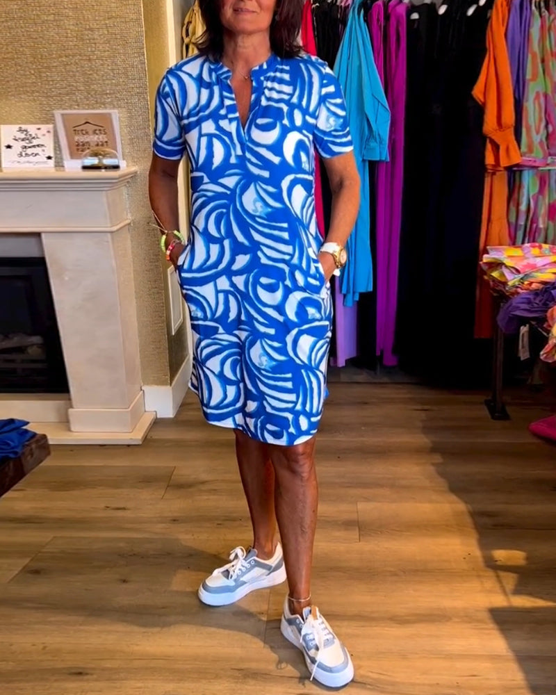 "Zomerjurk met korte mouwen, rood-witte abstracte print, casual en speels, perfecte outfit voor warme dagen."