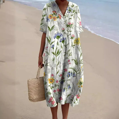 Zomerjurk Tess met bloemenprint, luchtige midi dress in kleurrijke bloemen, ideaal voor zonnige dagen met elegant design.