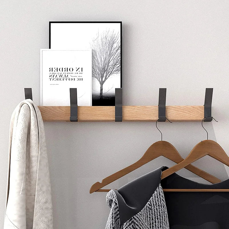 "Zwarte Scandinavische wandkapstok met verstelbare haken, houttinten. Modern minimalistisch design, duurzaamheid centraal."