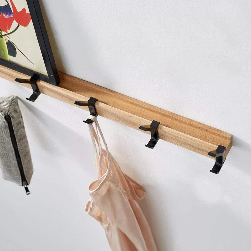"Zwarte Scandinavische wandkapstok met verstelbare haken, houttinten. Modern minimalistisch design, duurzaamheid centraal."